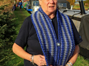 A neck scarf hand knitted aboard the narrow boat “Emma Maye” in Lancashire by Carole Wareing of Colin and Carole’s Creations. This one is knitted in a yarn that is in shades of blue and grey.