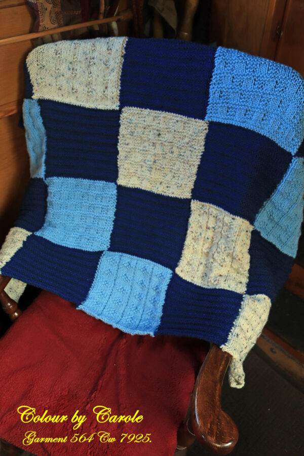 A lovely warm and snuggly hand knitted blanket in blue and cream shades. Blue and Cream squared blanket, designed to go over a person’s knees but could have many other many uses, such as a child’s bed blanket or a pet blanket. The blanket is easy care, being machine washable at 40C and measures 39 inches by 34 inches (64 by 64 cm) and has been created from James C Brett’s aran with wool knitting yarn. The design is 5 by 5 squares, with the patterning on the squares being based on fishermen’s gansey patterns. Carole Wareing has designed and hand knitted this blanket, this is Carole of Colin and Carole’s Creations based on a narrow boat named “Emma Maye” and also known as The Wool Boat that is based on the Leeds and Liverpool canal in Burscough in West Lancashire.