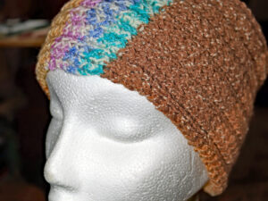 Brown Headband from Harmony A ribbed textured headband hand knitted aboard the narrow boat “Emma Maye” in Lancashire by Carole Wareing of Colin and Carole’s Creations. This unique garment is an adult sized headband. The garment is created from a yarn with shades of browns, blues, lilac’s and creams. The yarn is a cotton and acrylic mix, very warm and snuggly. Garment 432 Cw 6945 Price £10 or £15 post free p and p to the uk.