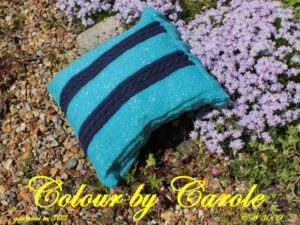 A cushion cover designed and hand knitted by Carole Wareing of Colin and Carole’s Creations and The Wool Boat. The cushion cover 15inches by 15 inches square, with two cabled panels with 6 buttons to close the access flap.