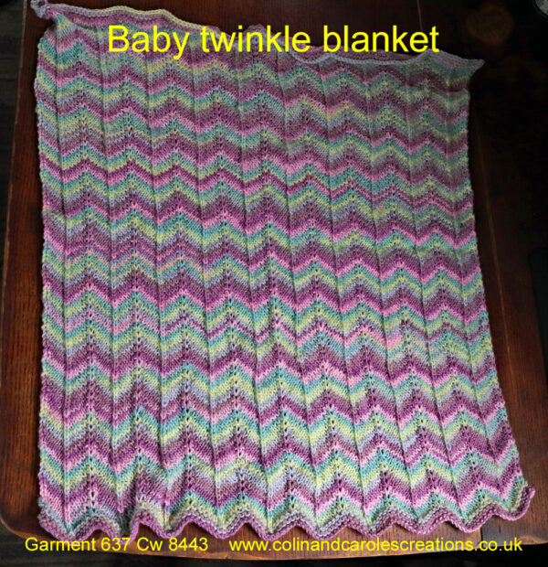 A lovely soft hand knitted baby blanket in colours of pastel and twinkly shades of pinks, lilac, green and lemon. The blanket has a chevron pattern knitted into it with the bottom border having a scalloped edge. The blanket is easy care, being machine washable at 30C and measures 19” by 24” (47 by 65 cm) and has been created from James C Bretts “Baby Twinkle Prints” acrylic double knitting yarn, shade Btp 23.