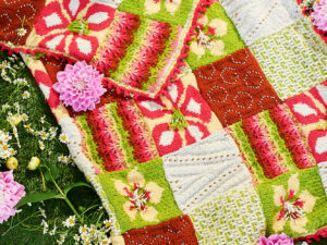 The UKHA, UK Hand knitting association, are organising a knit along for April into May 2026, to produce a blanket named “Bloom”. The pattern will be realised over 7 weeks from the 7th of April 2026 through the UKHA website and Ravlery. We have put together a pack of the seven shades of Top Value from James C Brett that can be used for this project. The pack contains 13 balls altogether in the required quantities of each shade. These may produce a brighter blanket than the one shown.