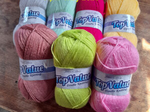 The UKHA, UK Hand knitting association, are organising a knit along for April into May 2026, to produce a blanket named “Bloom”. The pattern will be realised over 7 weeks from the 7th of April 2026 through the UKHA website and Ravlery. We have put together a pack of the seven shades of Top Value from James C Brett that can be used for this project. The pack contains 13 balls altogether in the required quantities of each shade. These may produce a brighter blanket than the one shown.