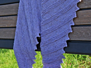 A Misty Dragon tooth shawl hand knitted aboard the narrow boat “Emma Maye” in Lancashire by Carole Wareing of Colin and Carole’s Creations. This unique garment is an adult sized shawl knitted from a now discontinued yarn we used to stock on The Wool Boat. The garment is created from a yarn with light shades of greys, from a yarn range called “Misty” thus the name of the shawl.