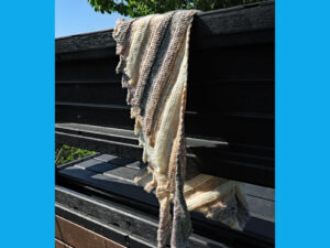 A Driftwood Dragon tooth shawl hand knitted aboard the narrow boat “Emma Maye” in Lancashire by Carole Wareing of Colin and Carole’s Creations. This unique garment is an adult sized shawl knitted from a now discontinued yarn we used to stock on The Wool Boat. The garment is created from a yarn with graduated shades of fawns and creams, from a yarn range called “Driftwood” thus the name of the shawl.