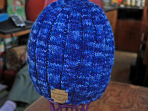 Blue Beanie hat hand knitted from British Wool Beanie hat in shades of blues. A blue adult beanie hat hand knitted aboard the narrow boat “Emma Maye” in Lancashire by Carole Wareing of Colin and Carole’s Creations. Great for an adult or teenager, Colour – shades of blues. British Wool with a nylon content which helps keep the hat tight to your head, machine washable at 40 degrees C on a gentle wool or wash cycle. The price is £15 or can be posted to a uk address with p and p if applicable. Created from a shade West Yorkshire Spinners yarn “Colour Lab DK” range which we stock on The Wool Boat. Hand knitted by Carole Wareing Garment 766 Cw 9470 Garment 766 Garment 766 Cw 9470 Colin Wareing Image Cw 9470 copyright Colin Wareing of Colin and Carole’s Creations www.thewoolboat.co.uk www.colinandcarolescreations.co.uk Garment 766 Cw 9470 E-mail colinandcarolescreations@yahoo.co.uk Phone no 07931 356204