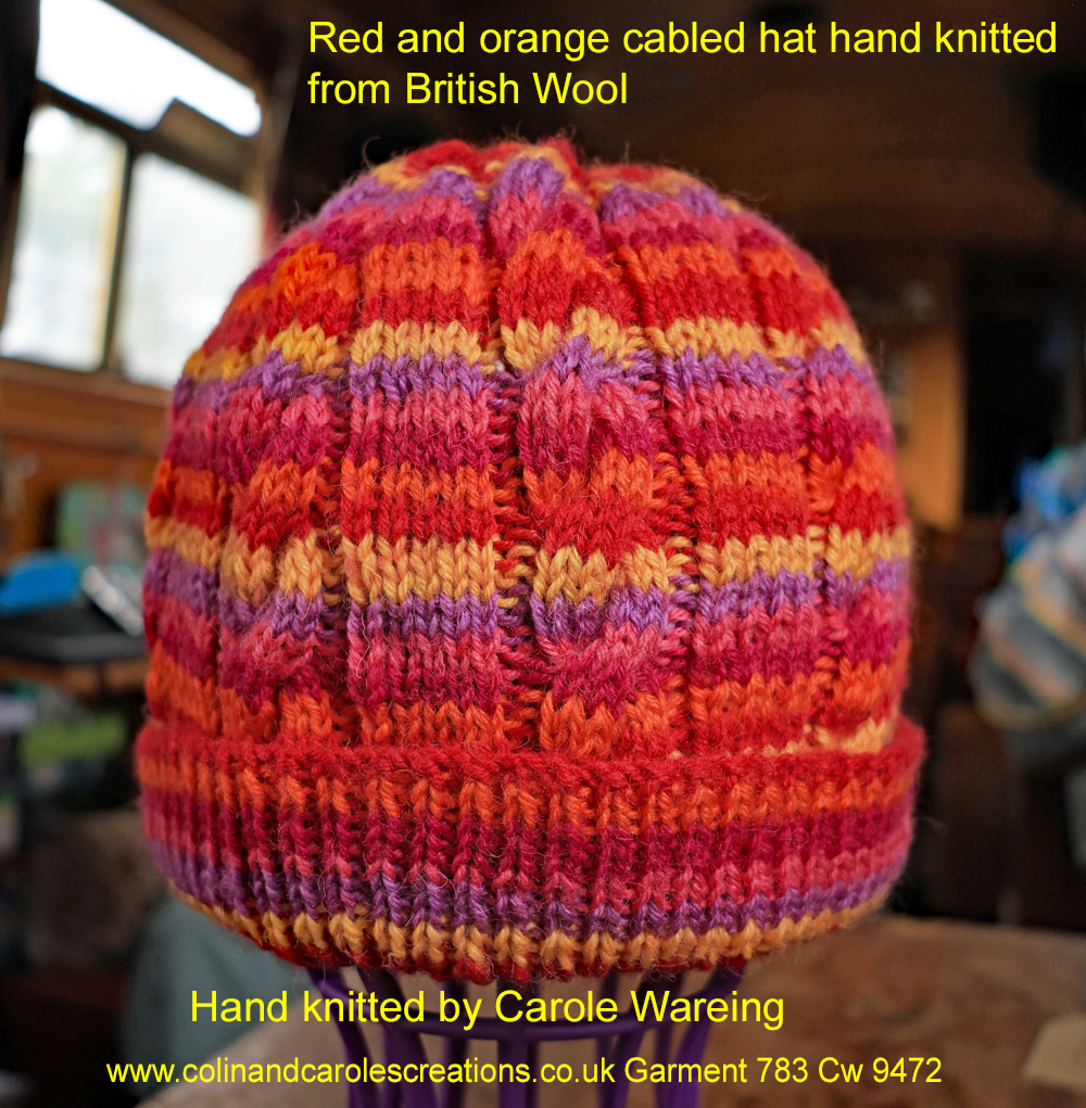 Cabled Tutti Frutti adults’ hat in shades of red and orange. A red and orange adult cabled hat hand knitted aboard the narrow boat “Emma Maye” in Lancashire by Carole Wareing of Colin and Carole’s Creations. Great for an adult or teenager, Colour – shades of red and oranges. British Wool, reared, sheared, spun and hand knitted in Britian. Machine washable at 40 degrees C on a gentle wool or wash cycle. The price is £15 or can be posted to a uk address with p and p if applicable. Created from shade “Tutti Frutti” from West Yorkshire Spinners yarn “Colour Lab DK” which we stock on The Wool Boat. Hand knitted by Carole Wareing Garment 783 Cw 9472